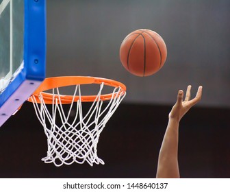 Orange basketball ball flying into the basketball hoop