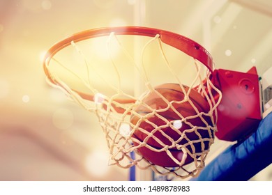 Orange basketball ball flying into the basketball hoop - Powered by Shutterstock