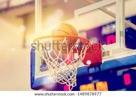 Orange basketball ball flying into the basketball hoop