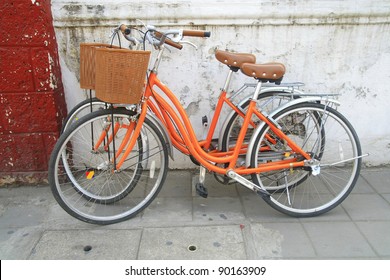 orange bicycle park near wall