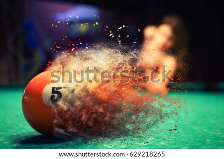 Orange billiard ball splits into particles and debris upon impact