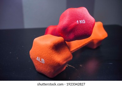 Orange And Blue Dumbell Concept Equipment.Isolated