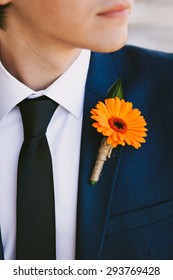 Orange Boutonniere. Groom in the wedding suit.