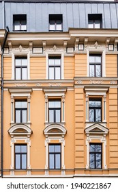 Orange Brick Art Nouveau Building Façade With Nine Cream Windows In Riga, Latvia, Europe