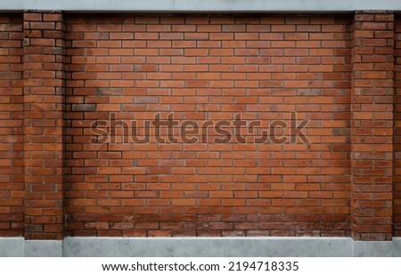 Orange brick wall with columns on the sides and white cement borders on the top and bottom