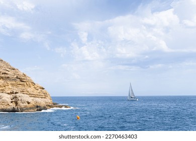Orange buoy and sailboat in Cabo de la Nao, Gulf of Valencia. Alicante, Valencia, Spain.
