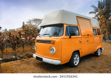 orange camper van parked in the park 