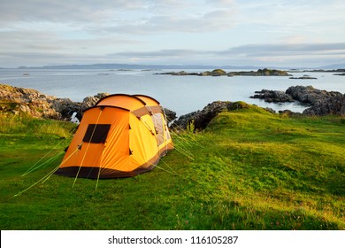 Orange camping tent on a shore in a morning light - Shutterstock ID 116105287