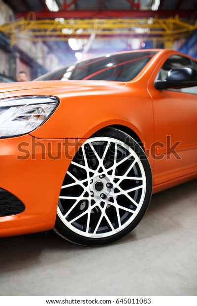 Orange car with alloy wheel
indoor.