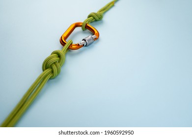 Carabiner with a Rope Lies on a Colored Background. Equipment for