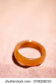 Orange carnelian stone ring blurry background  Vertical photo in macro style  There is space for text 