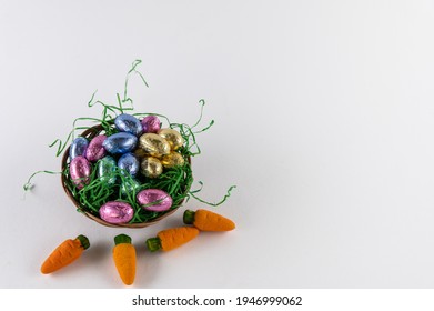 Orange Carrots And A Filled Easter Basket With Sweet Eggs