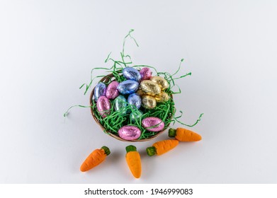 Orange Carrots And A Filled Easter Basket With Sweet Eggs