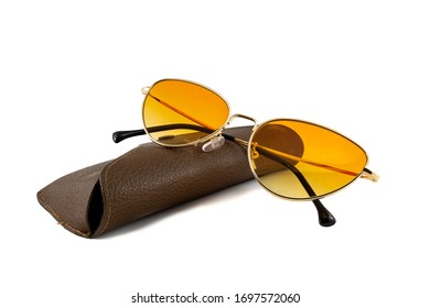 Orange Cat Eye Sunglasses With Gold Wrap Around Frames And Brown Eyeglasses Case Isolated On White Background, Folded Side View