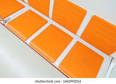 Orange Chairs On White Background. A Row Of Plastic Chairs. Orange Seat In A Subway. Seats In The Cabin. Ergonomic Chair. Places For Passengers In Public Transport.