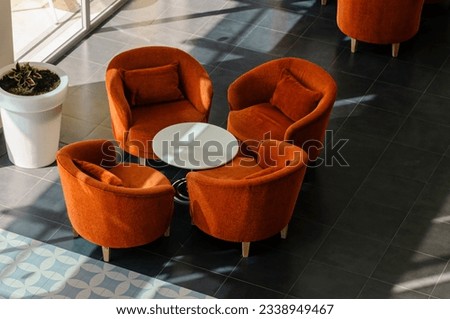 Orange chairs and table in a hotel lobby