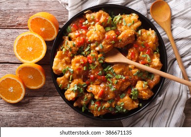 Orange Chicken In Sweet And Sour Sauce On A Plate Close-up On The Table. Horizontal View From Above
