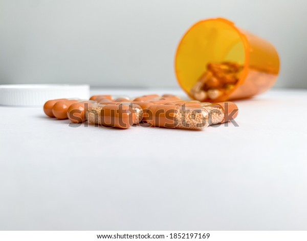 Orange and clear\
capsules of Amphetamine salts, Adderall XR 30 mg pills spilling out\
of orange pill bottle.
