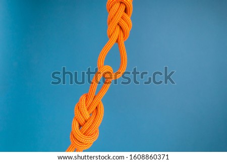 Orange climbing rope. Climbing equipment. Knot eight. Noose. Reliable node for belaying. Two ropes connected among themselves.