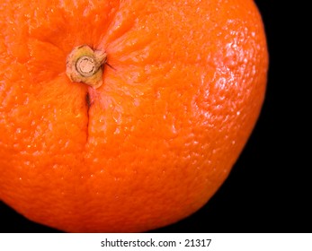 Orange closeup on a pure black background.  Detailed texture.