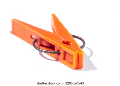 Orange Clothespin Close-up On A White Background. Plastic Old Clothespin For Laundry