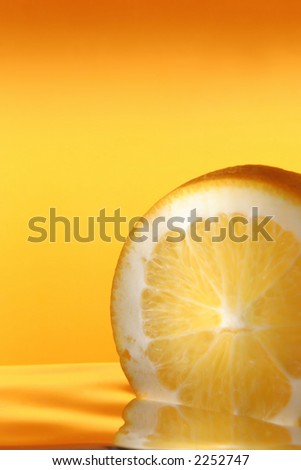 orange in cocktail on yellow background