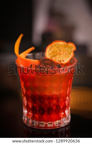 Orange cocktail in retro glass on black background