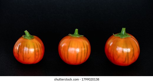 Orange Color Eggplants With Stripes On Black Background. Three Turkish Orange Heirloom Eggplants In A Row.