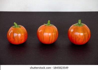 Orange Color Eggplants With Stripes On Black Background. Three Turkish Orange Heirloom Eggplants In A Row.