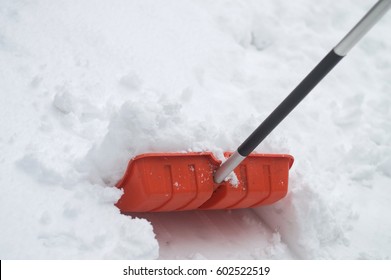 Orange Color Snow Shovel Middle Width Half Way In Snowbank. No People, Isolated Spade.