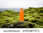 An orange coloured water bottle in the mountains.