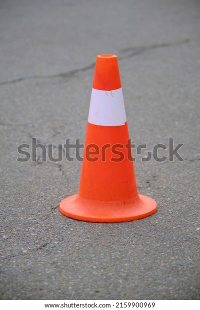Orange cone on the\
asphalt.