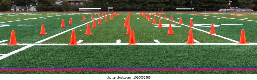 Orange Cones Are Set Up On A Green Turf Field For A Track And Field Teams Speed And Agility Training.