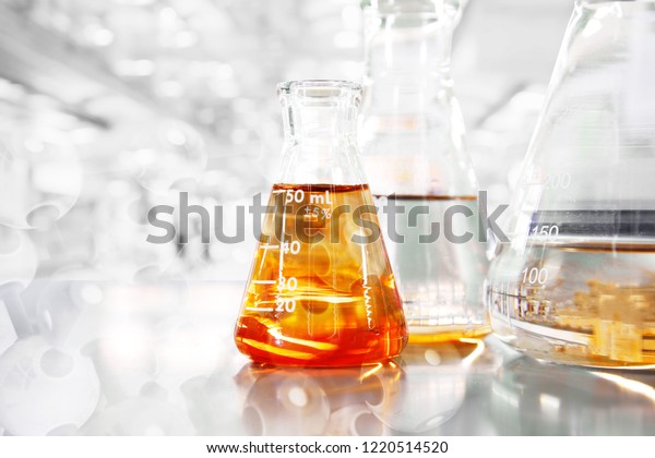 orange so in conical\
three flasks with chemical structure in science education\
laboratory background