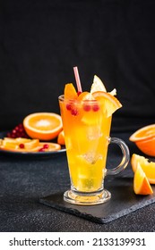 Orange Cranberry Fizzy Cocktail In A Glass And Fruits Next To It On A Dark Background. Homemade Mocktail. Vertical View