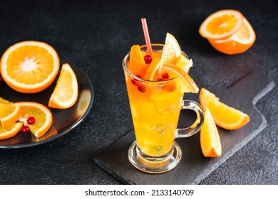 Orange Cranberry Fizzy Cocktail In A Glass And Fruits And Berries Nearby On A Slate On A Dark Background. Homemade Mocktail