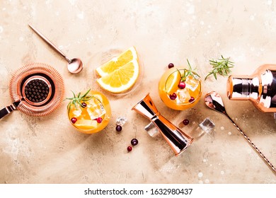 Orange Cranberry Rosemary And Vodka Cocktail, Copper Bar Tools, Beige Background, Hard Light, Top View