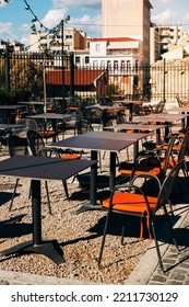 Orange Cushions On Metal Chairs In Empty Patio