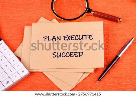 Orange desk with Plan Execute Succeed cards, calculator, magnifying glass, pen. Symbolizes strategic achievement.