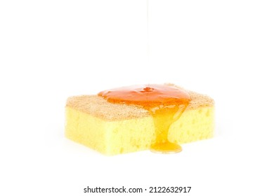 Orange detergent pouring onto yellow cleaning sponge isolated on white. Orange gel dish soap on porous sponge, home cleaning concept. Dishwashing sponge for general cleaning day, white background - Shutterstock ID 2122632917