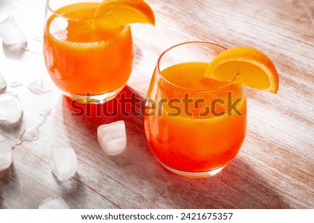Orange drinks on a wooden background, fresh pressed juice with fruit slices and ice