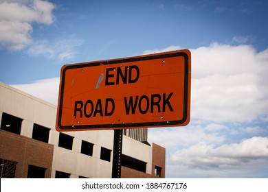 An Orange End Road Work Construction Sign On The Street Showing The End Of A Zone Where Road Work Is Being Done.