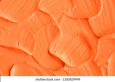 Orange facial mask (pumpkin cream, body scrub) texture close up. Abstract background with brush strokes.