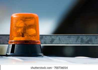 Orange flashing and revolving light on top of a support and services vehicle