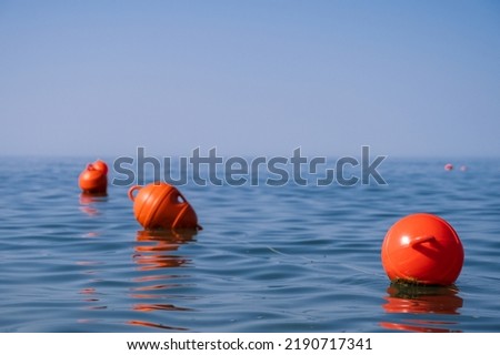 Orange floating buoys in the sea. Human life saving concept. Blue sky.