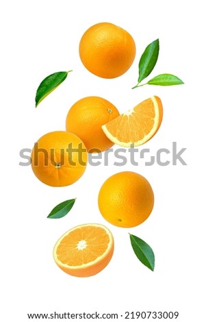 Orange fruit with cut half sliced and green leaf flying in the air isolated on white background.
