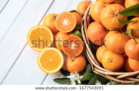 Orange fruit with green leaves on the white wood.  Home gardening. Mandarine oranges. Tangerine  oranges. Orange color. Fresh orange juice.
