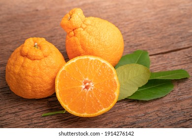 Orange Fruit On Wooden Table , Dekopon Orange Or Sumo Mandarin Tangerine With Leaves In Wooden Background.