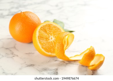 Orange fruits with peel on white marble table