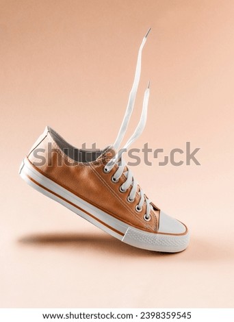 Orange fuzz color classic vintage sneaker floats in the air 